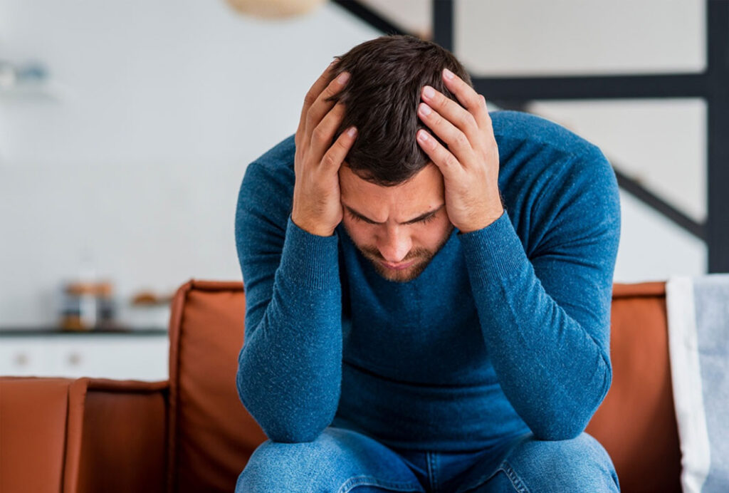 A man holding his head because of a headache.