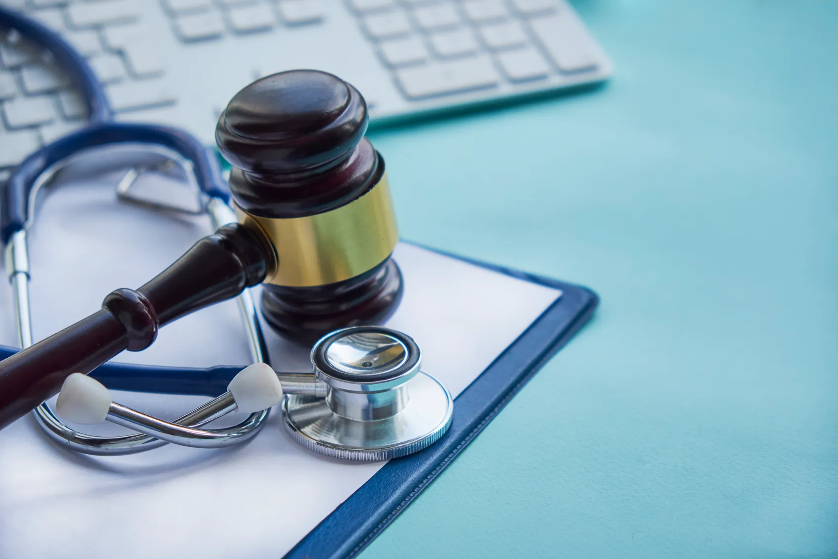 A gavel and a stethoscope on paperwork.