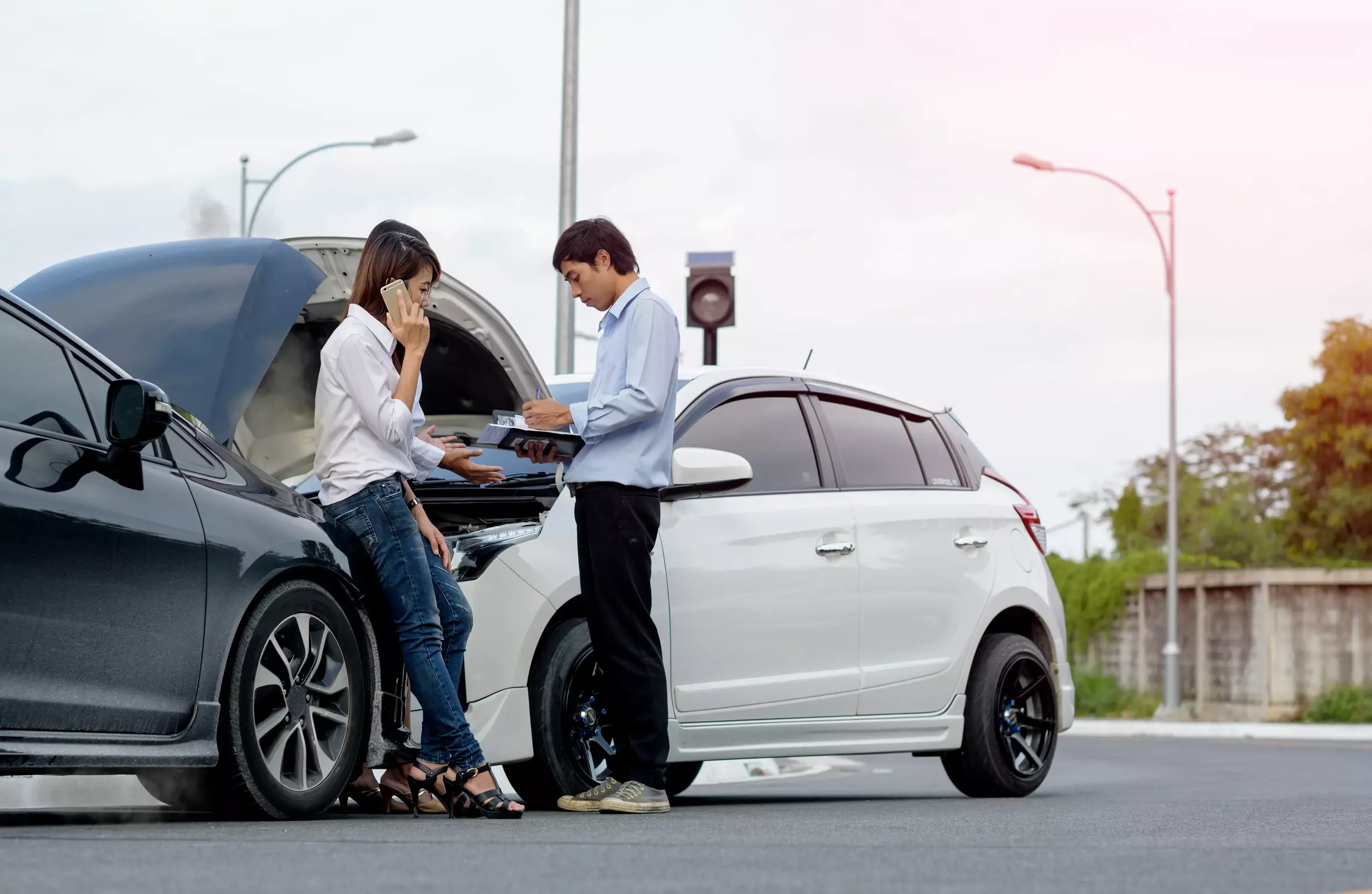 man and woman getting insurance info after a car wreck.