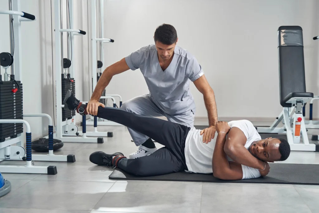 A doctor helping patient with therapy exercises.